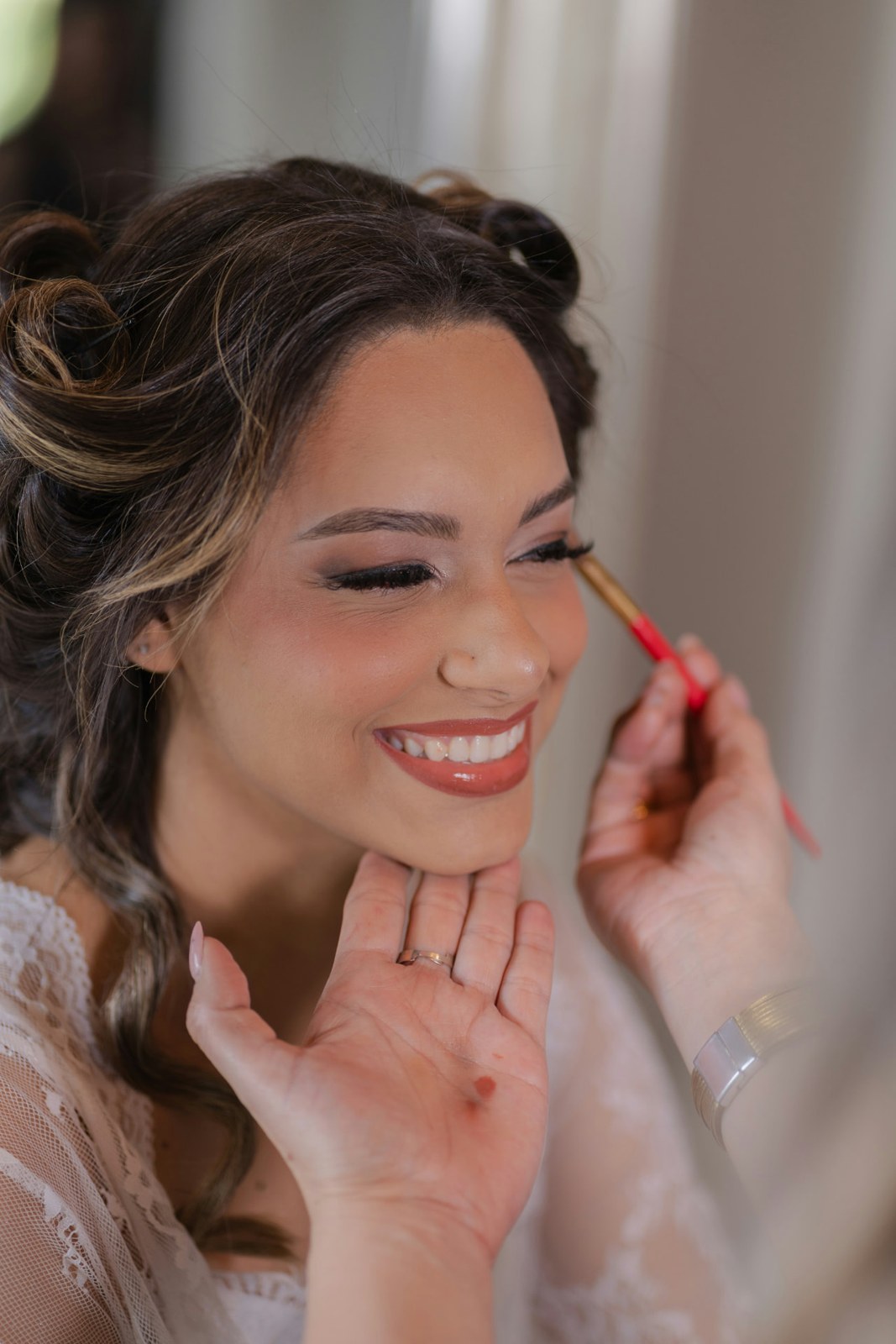 Eine lächelnde Braut bei der persönlichen Make-up-Vorbereitung