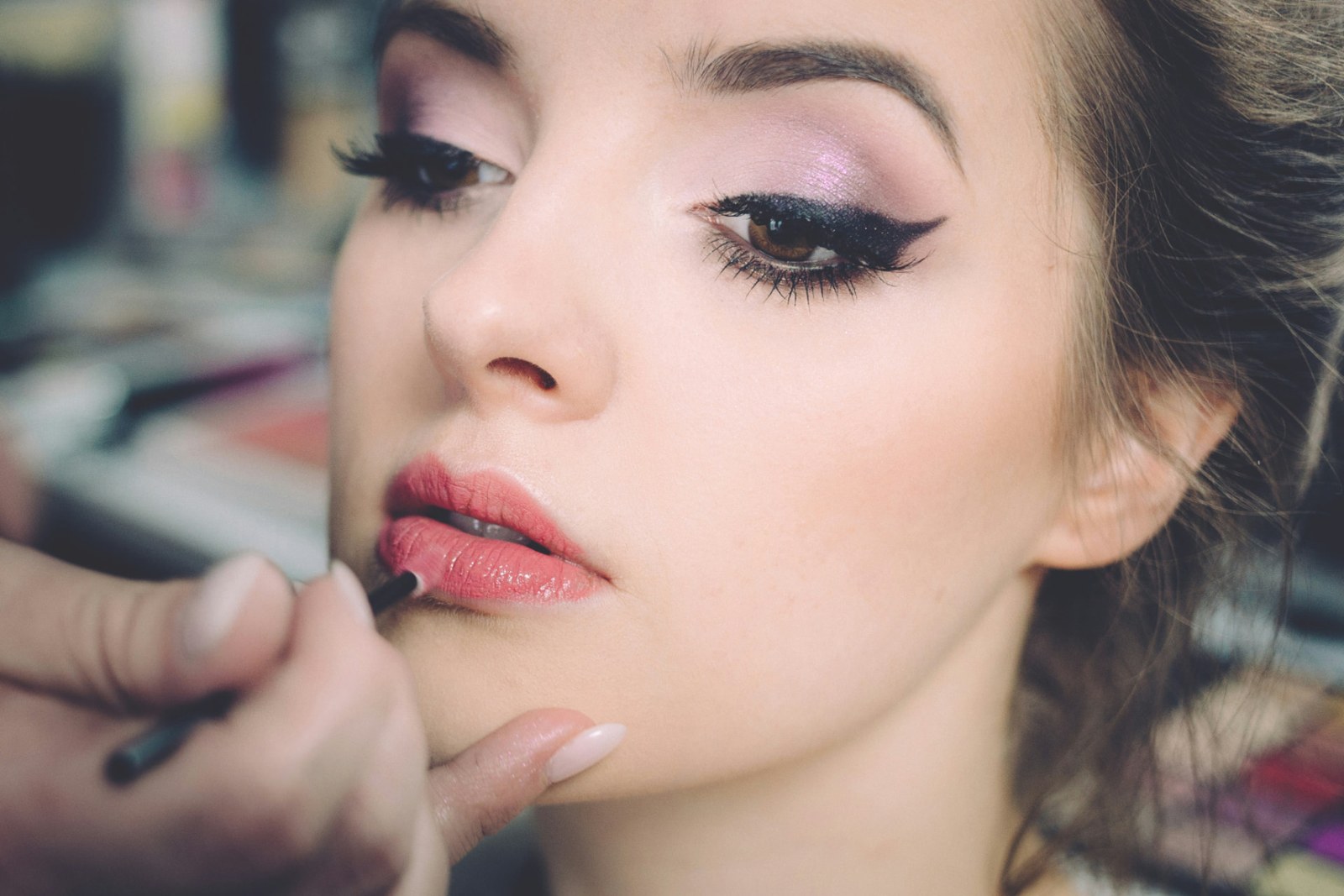 Lippen-Make-up wird mit einem Pinsel von Hand aufgetragen